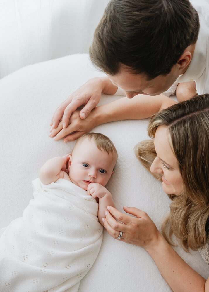 parents overlooking newborn - photographed by Natasha Cranley