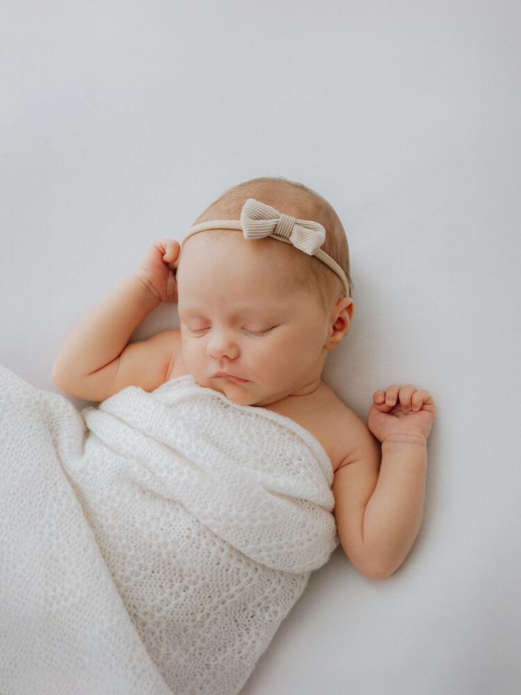 Newborn sleeping wrapped in blanket - photographed by Natasha Cranley